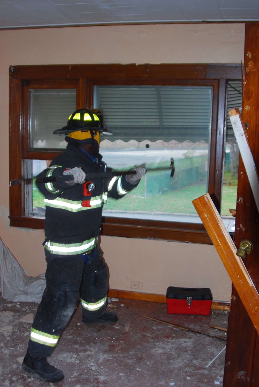 Firefighter forcing a window during training