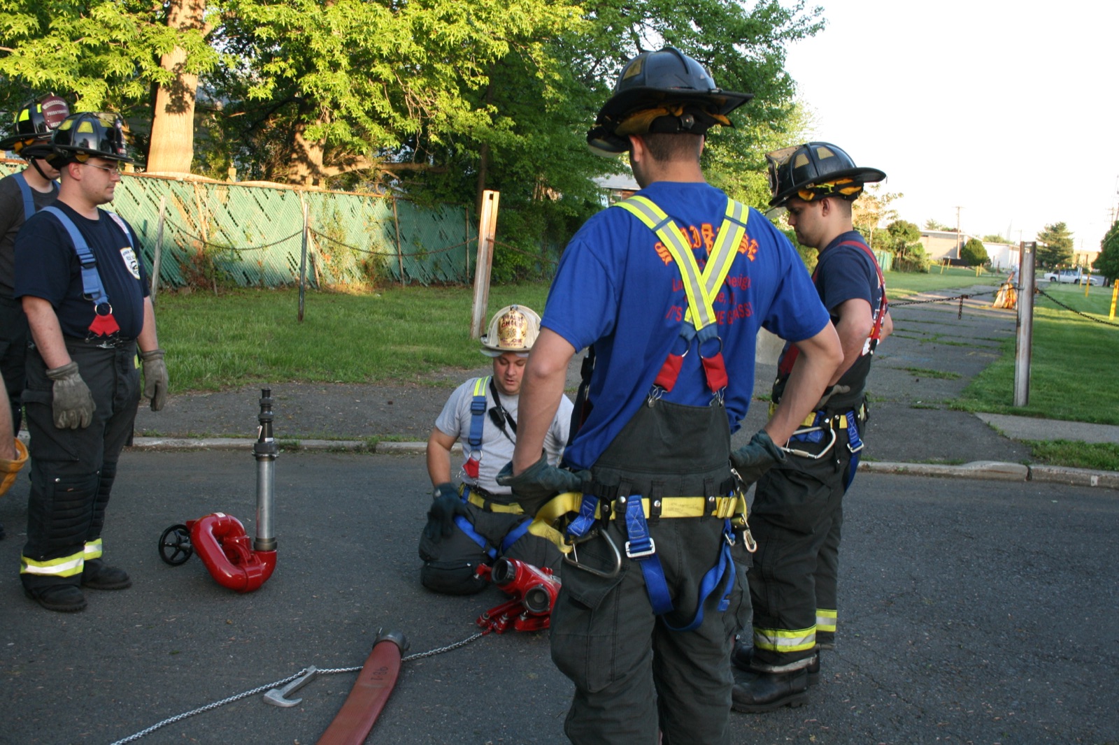 Firefighters training with hose and appliances at a daytime drill
