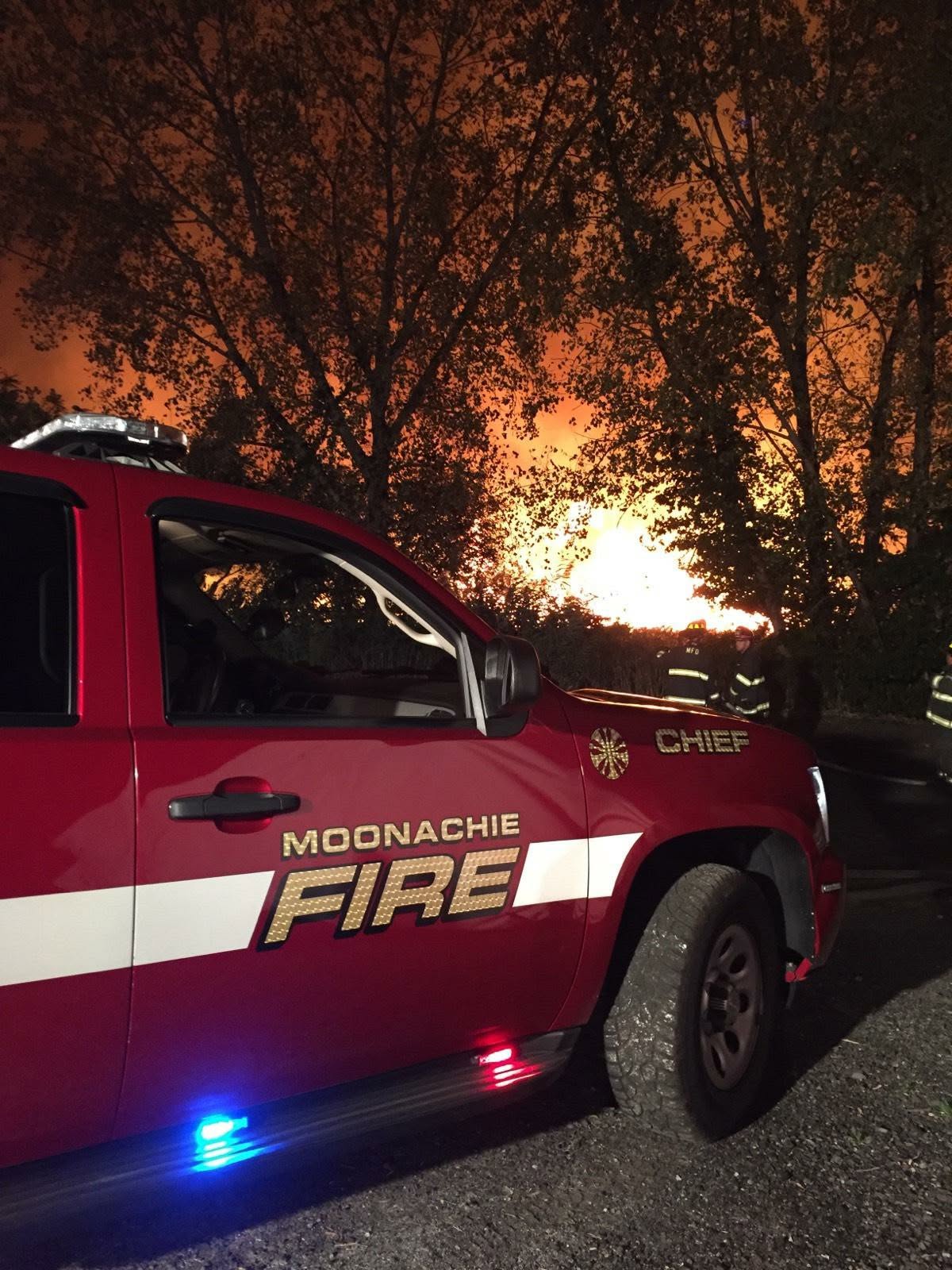 Chief vehicle on scene with fire glow at dusk